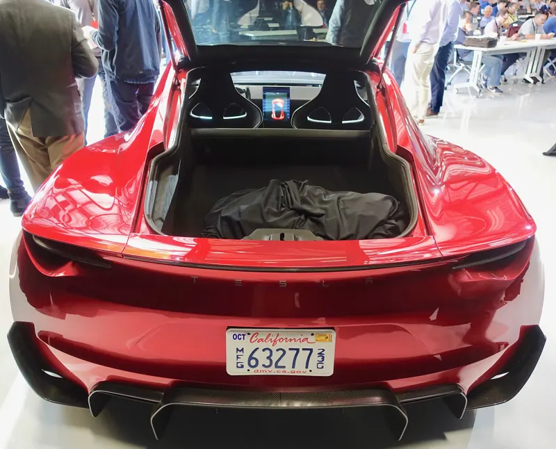 Rear view of the red Roadster prototype with the rear hatch and the glass roof panel stowed in the trunk
